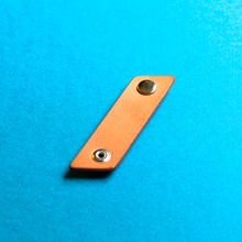 Load image into Gallery viewer, Brown leather strap with metal fasteners on a blue background, open