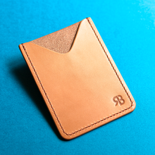 Load image into Gallery viewer, Full-grain hand-stitched brown leather cardholder with &#39;RB&#39; logo on a blue background, front